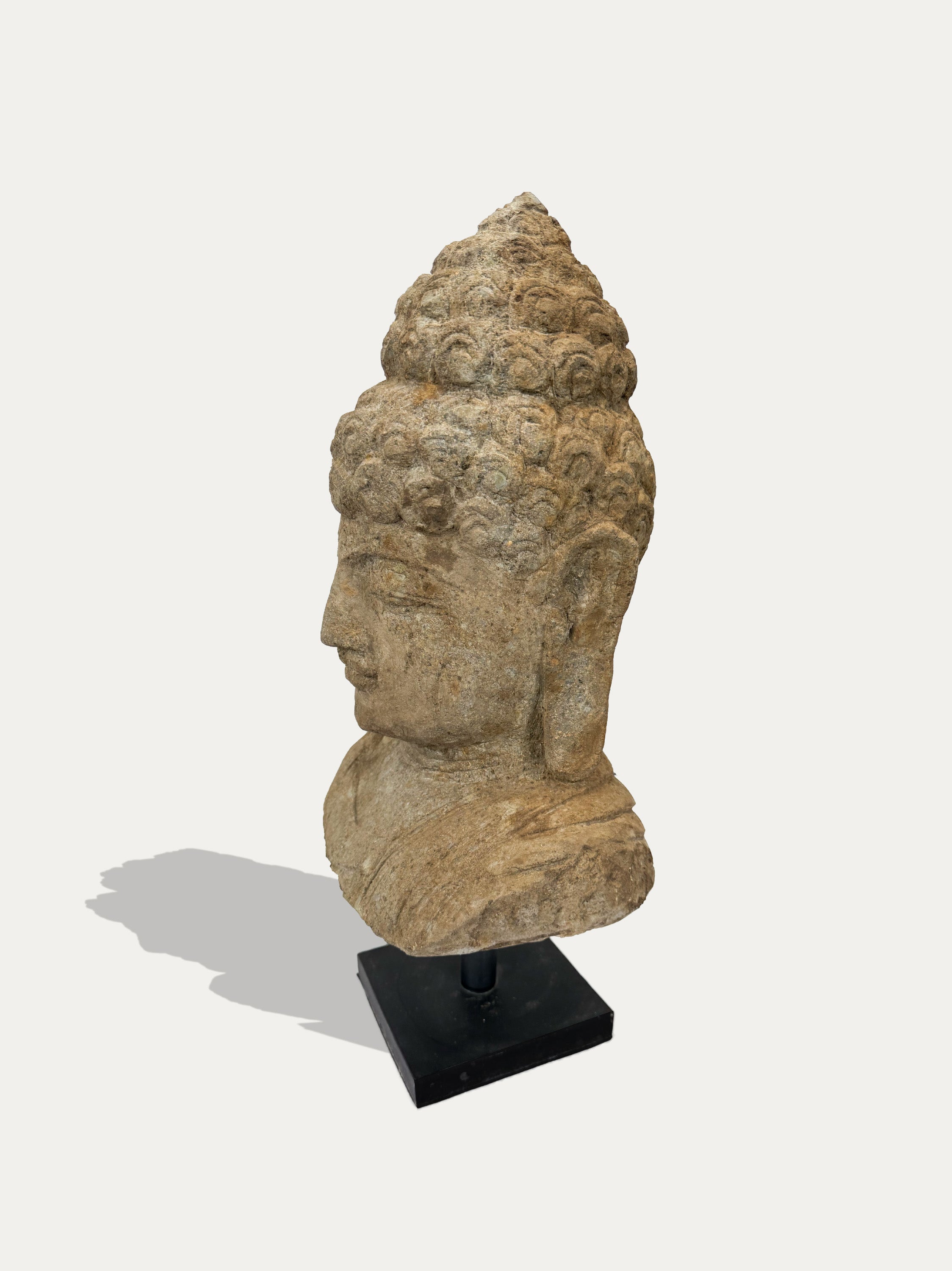 Side view of hand-carved Buddha head statue from Java on display at Kirschon, Lake Como