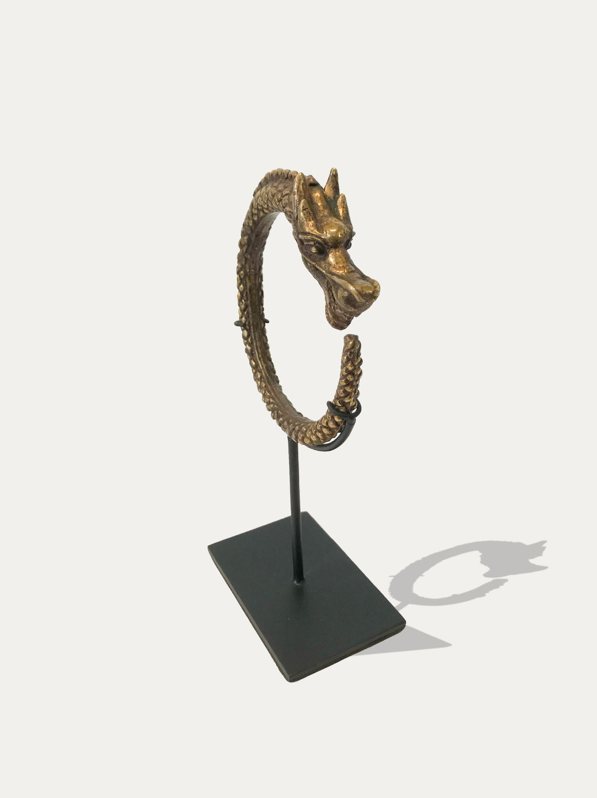 Immortal Legacy Indonesian art bundle with Borneo Naga bangles and a Sumatran brass cuff on metal stands