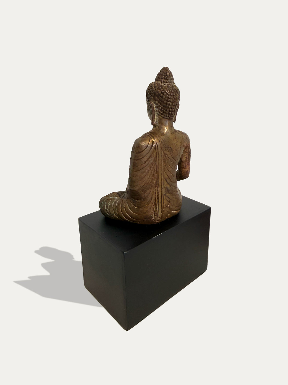 Buda javanés sentado de bronce con gesto de la tierra como testigo sobre soporte de metal negro