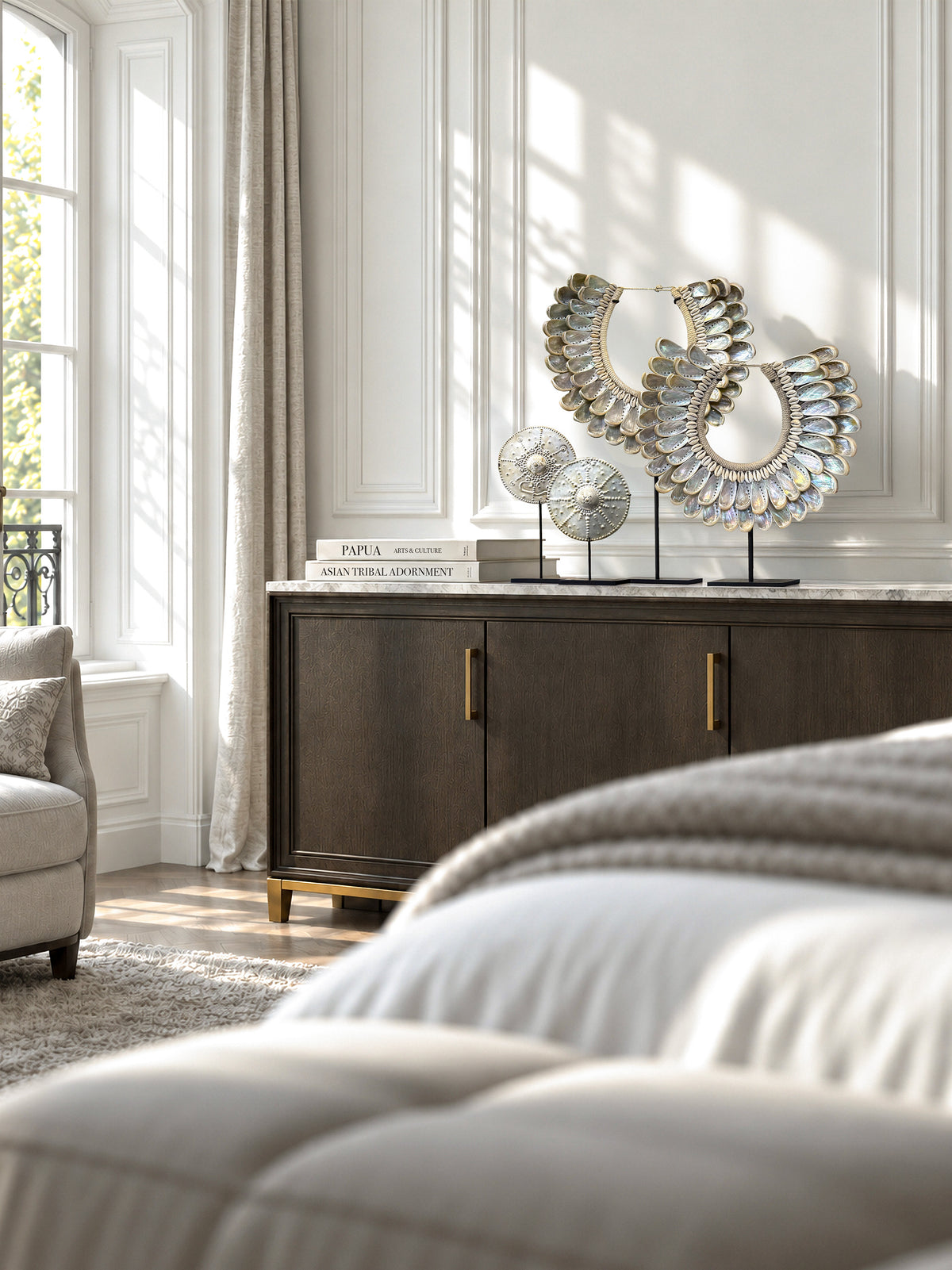 Treasures of the Tides: two Papua abalone necklaces and two Timor silver-coloured brass pectoral plates displayed in a sunlit bedroom.
