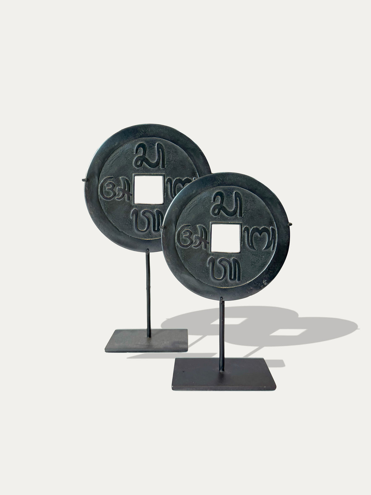 Set of two sacred Balinese Pis Bolong coins on black metal stands