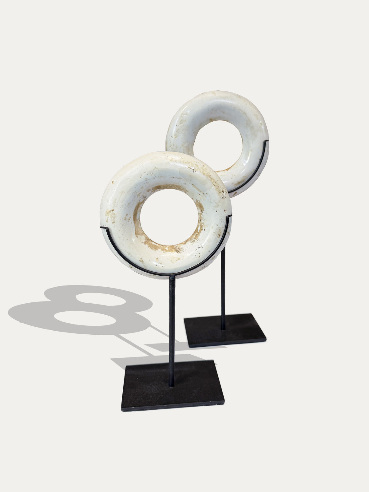 Pair of tribal money rings from Papua New Guinea displayed on handmade metal stands